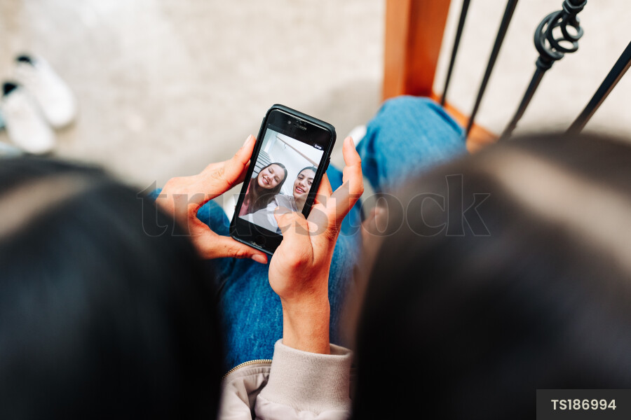 Top view of friends taking selfie on staircase
