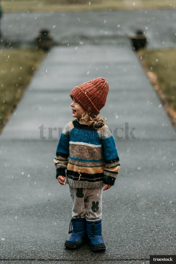 Young Girl Standing on Path while its Snowing