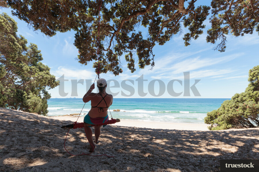 Adult on a swing at the beach