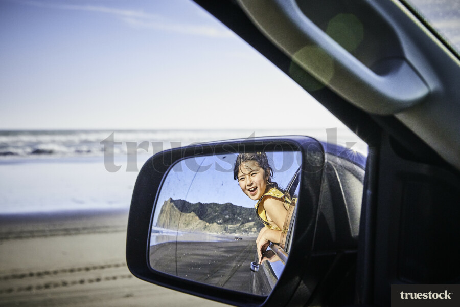 Girl Reflected in Car Mirror at Beach