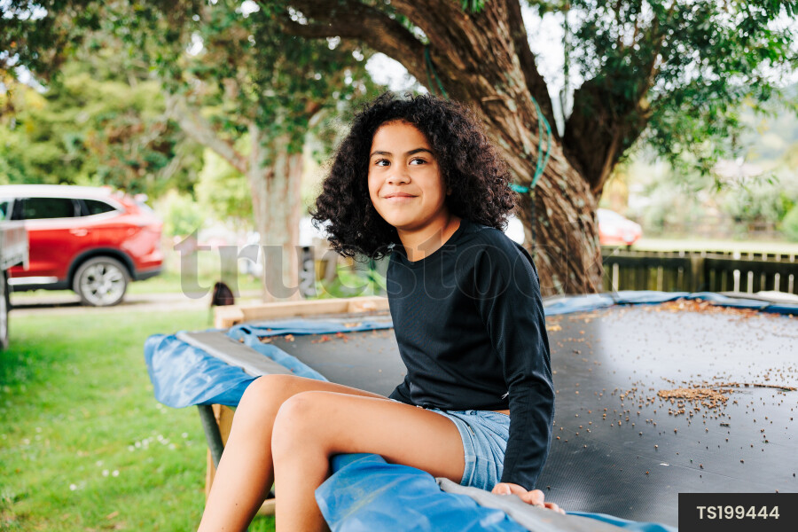 Young Girl Sitting On Trampoline