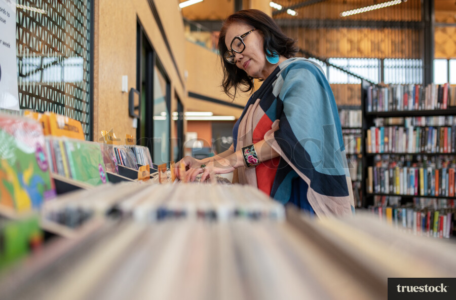 Woman Selecting Book in Library