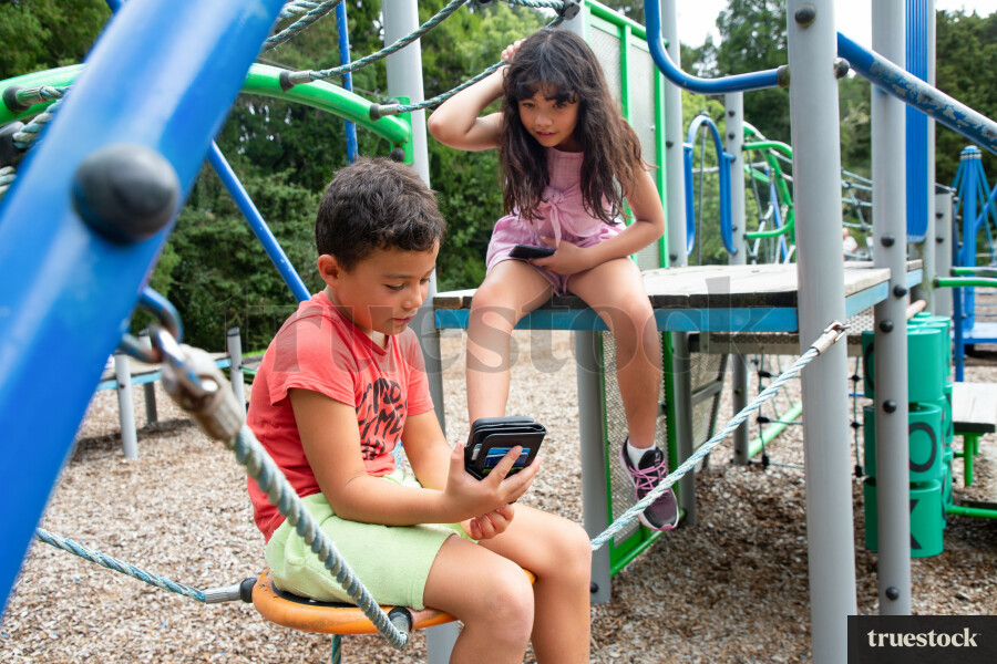 Child Looking at Phone, at Playground