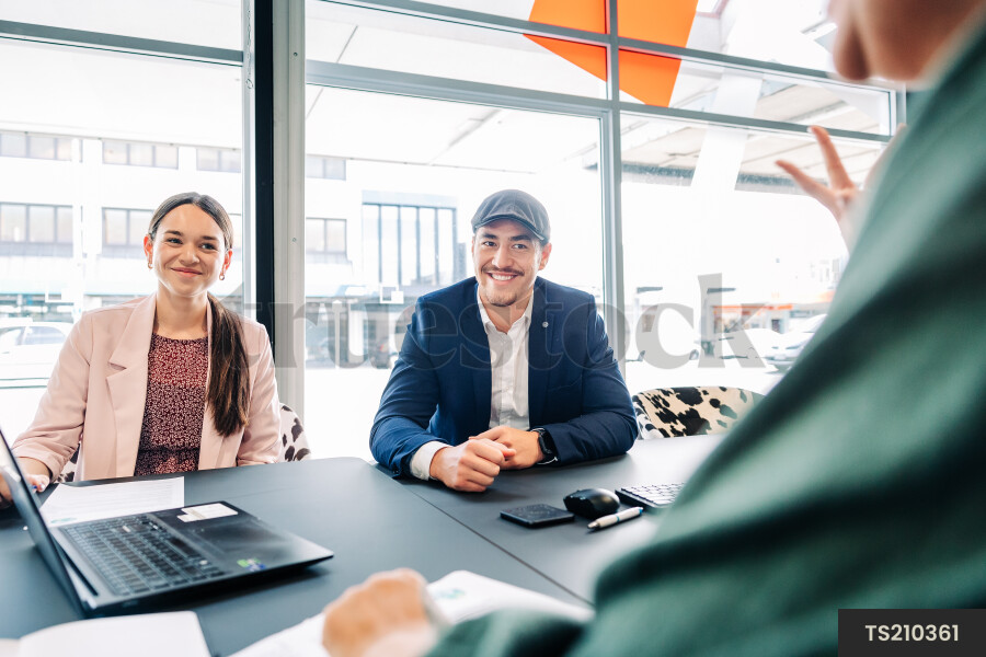Businesspeople using laptop during meeting in boardroom