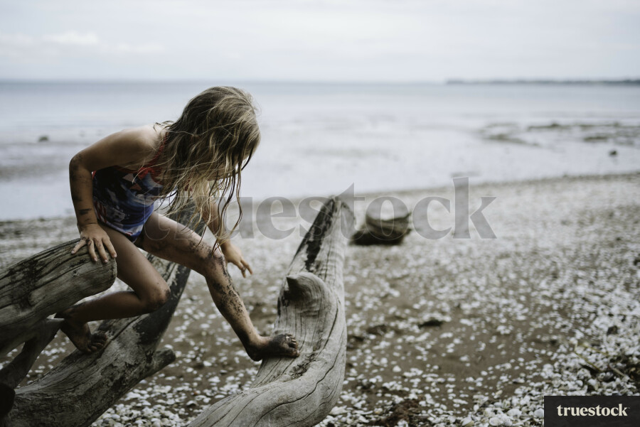 Girl Climbing Driftwood