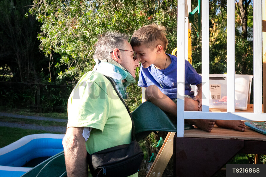 Man playing with grandson in playhouse