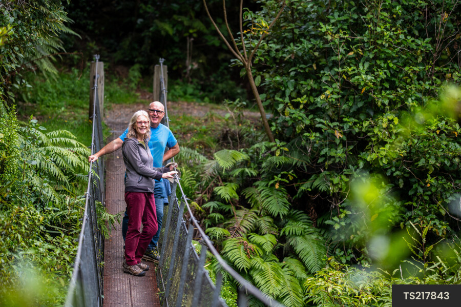 Couple hiking on bridge in forest