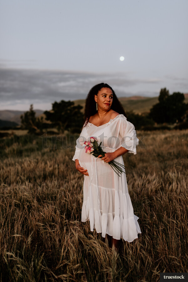 Woman Holding Flowers for Maternity Shoot