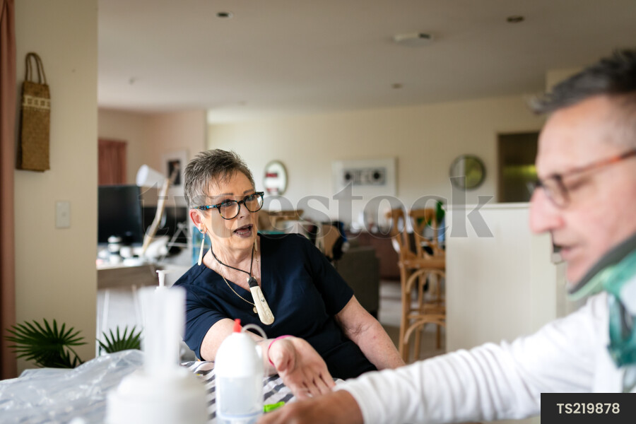 Health carer giving medicine to patient with neck brace