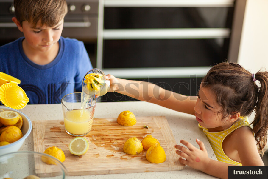 Young children making lemondade