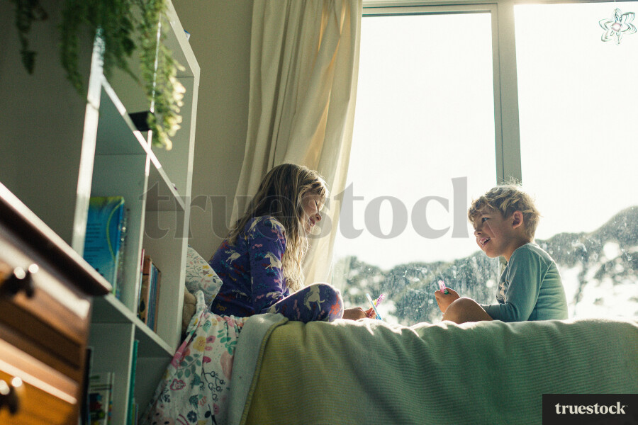 Siblings Sitting on Bed