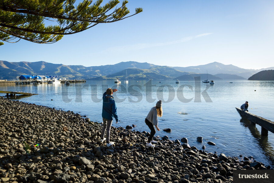 Teenagers Throwing Stones in Water