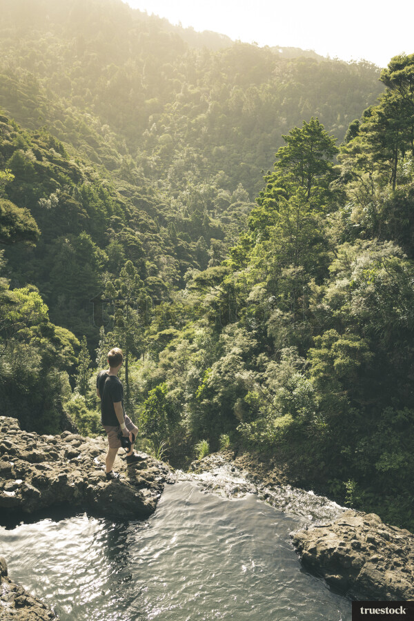 Man Standing at Top of Waterfall