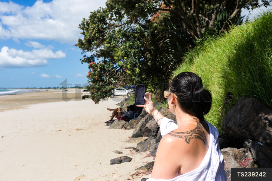 Woman taking selfie on beach