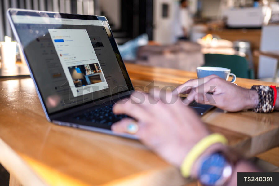 Small business owner working at laptop in cafe