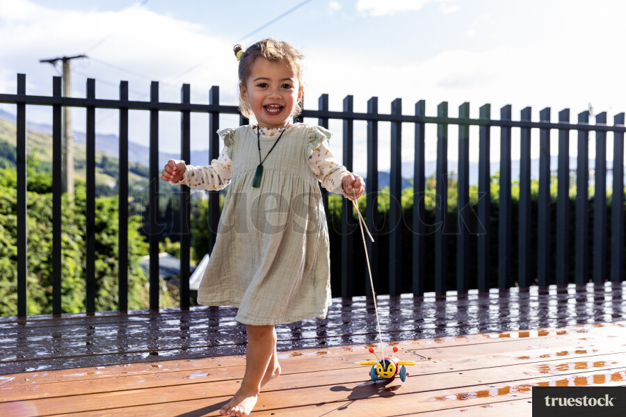Young Girl Playing With Toy on Deck