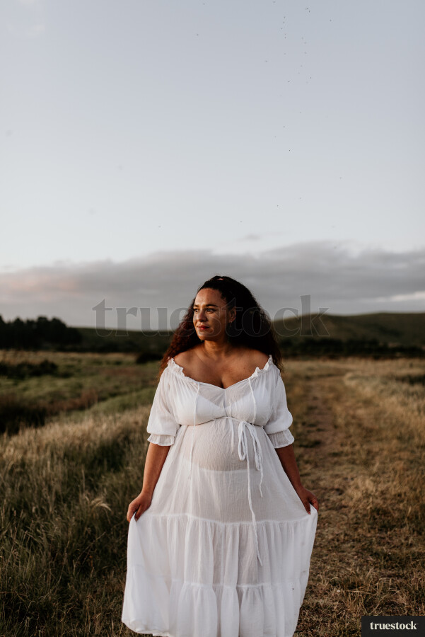 Woman Standing in Field for Maternity Shoot
