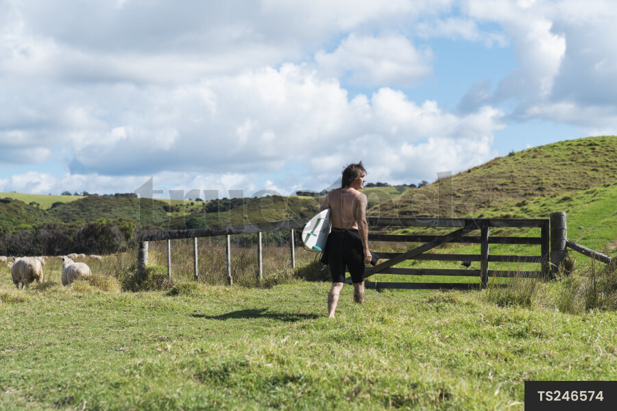 Surfer with surfboard in paddock