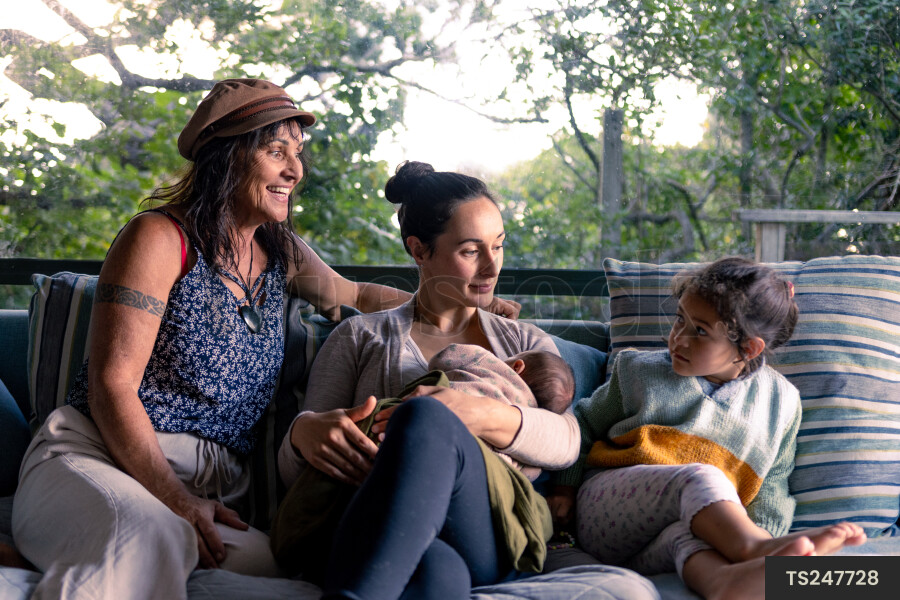 Family sitting and smiling on sofa in living room