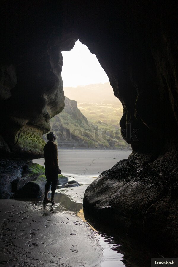 Man standing in Cave at Beach