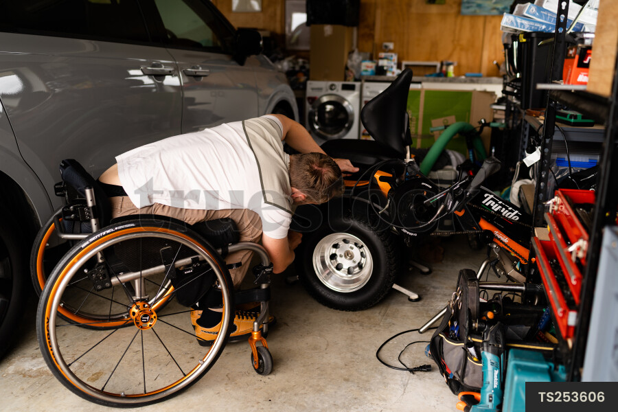 Man in wheelchair doing DIY in garage