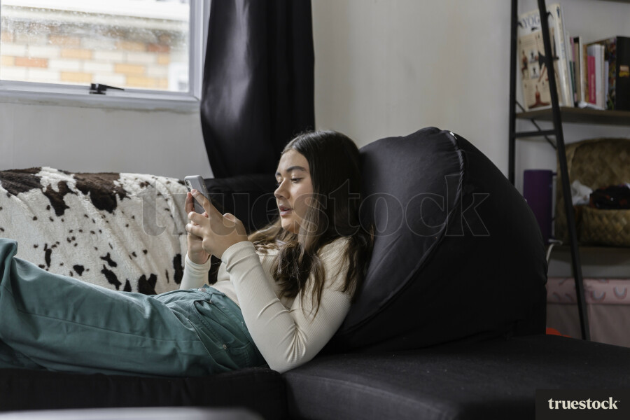 Teen Girl Using Phone on Couch