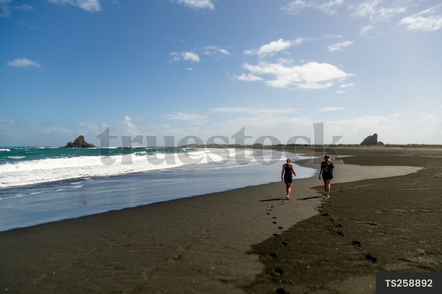 Women walking on Whatipu Beach, Auckland