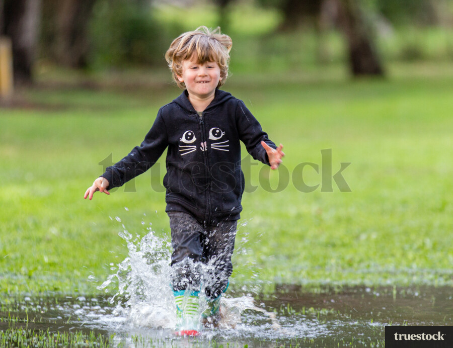Toddler running in a puddle