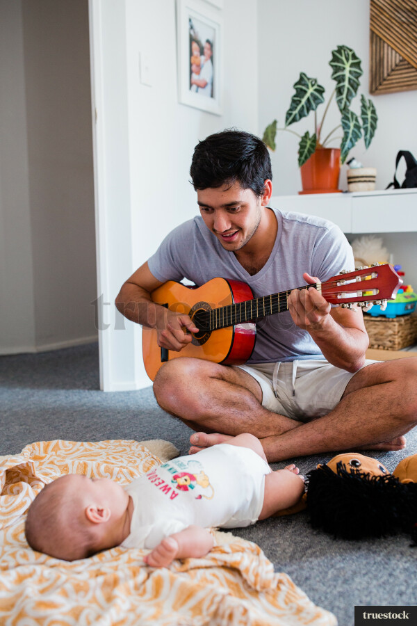 Father playing guitar with baby