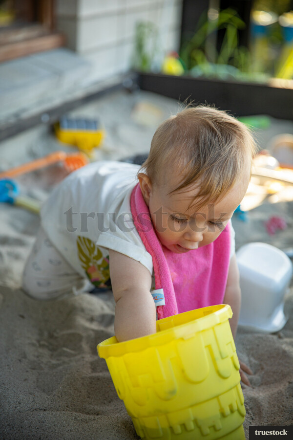 Toddler playing in the sandpit in the backyard
