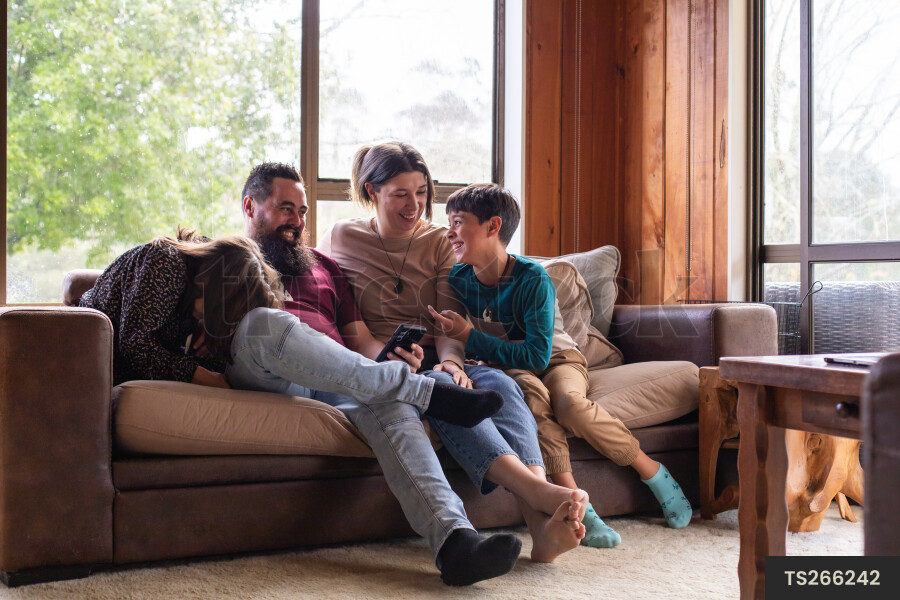Family Using Phone on Couch