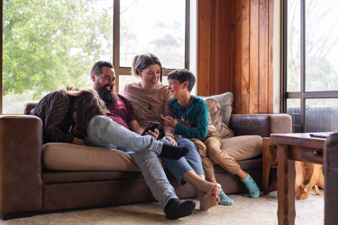 Family Using Phone on Couch