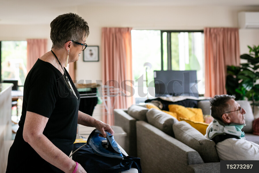 Health carer ironing clothes for patient