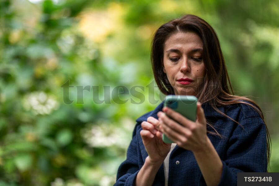 Young woman with smart phone in park