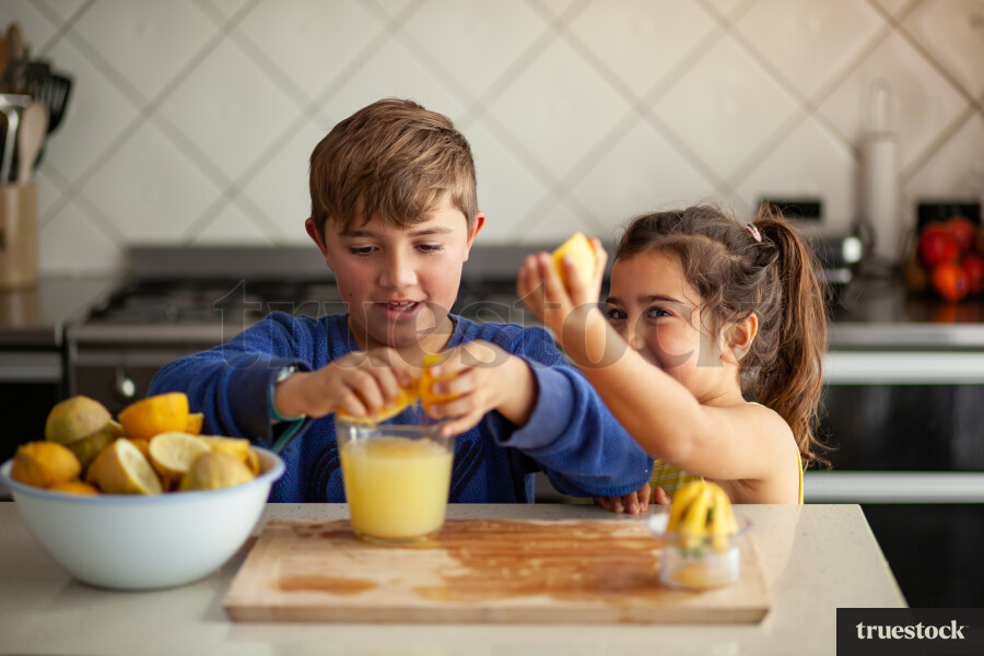 Young children making lemondade