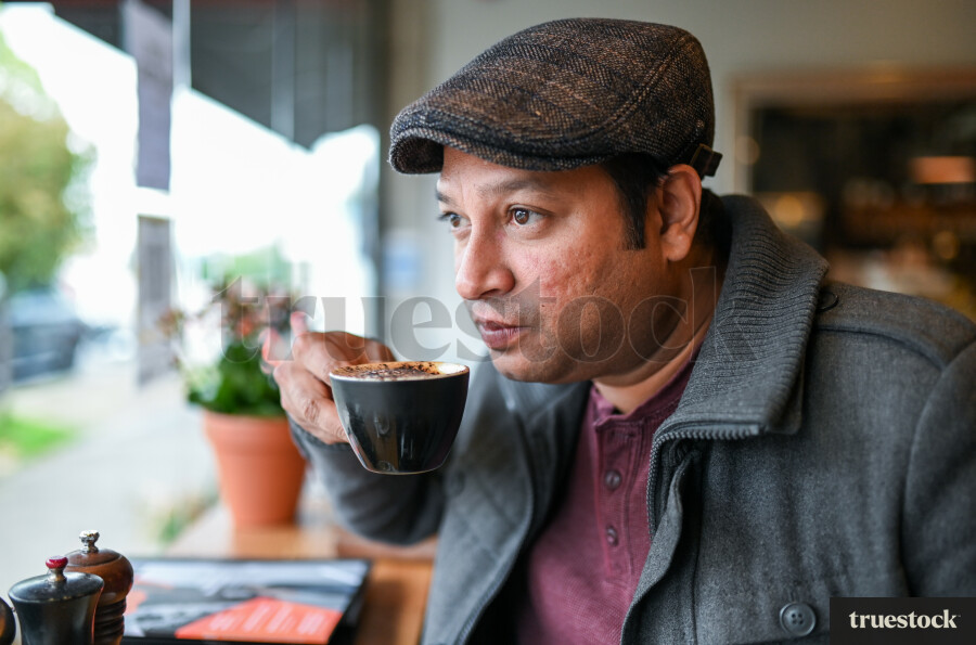 Adult male in a cafe drinking a coffee