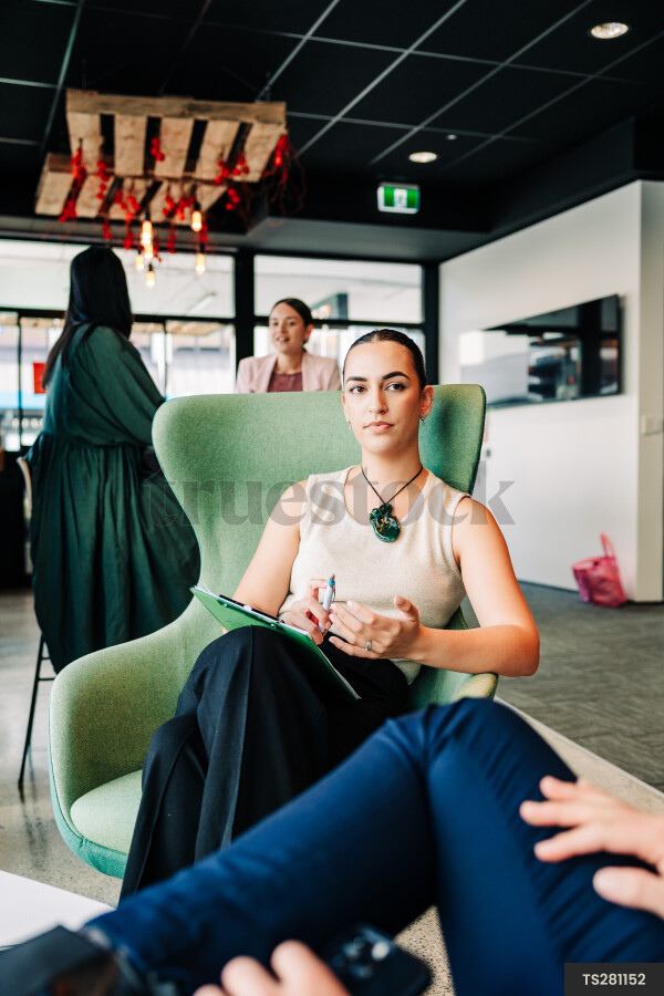 Young businesspeople sitting on chairs in office building