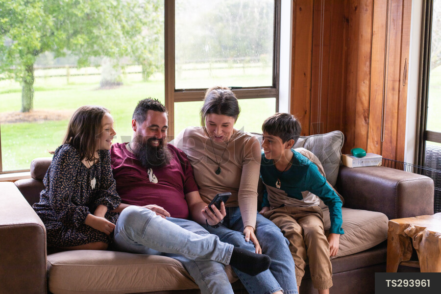 Family Using Phone on Couch