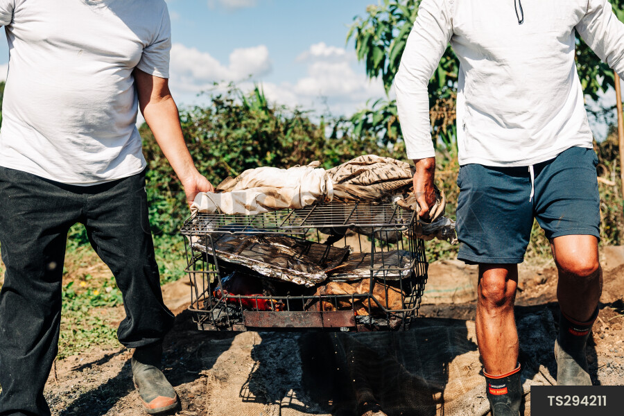 Father and son carrying grill basket in back yard