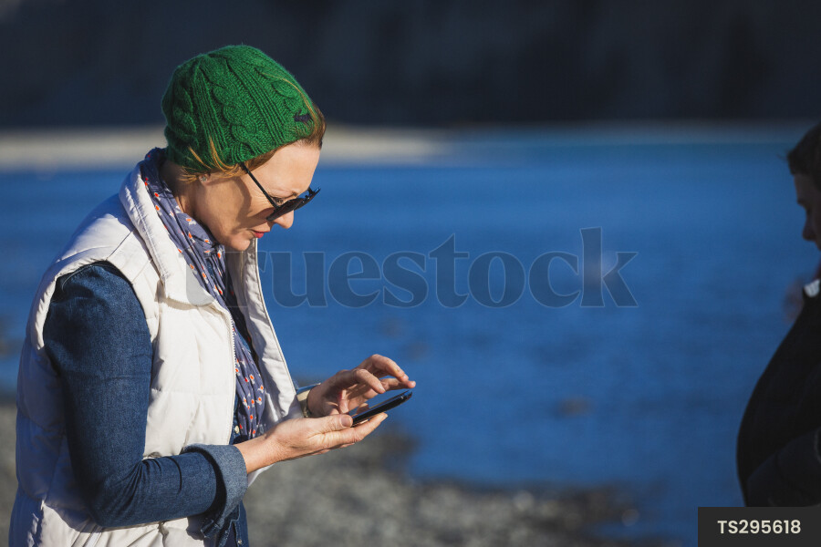Woman with smart phone by lake