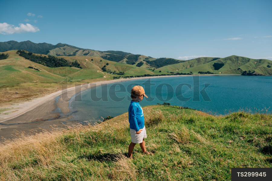 Boy on hill along coastline