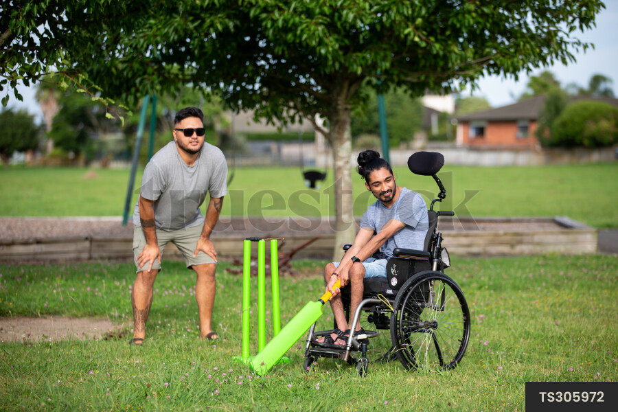 Friends playing cricket at park