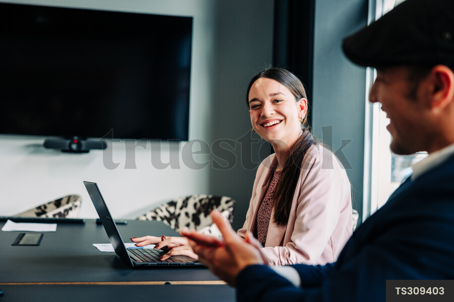 Businesspeople with laptop during meeting in boardroom