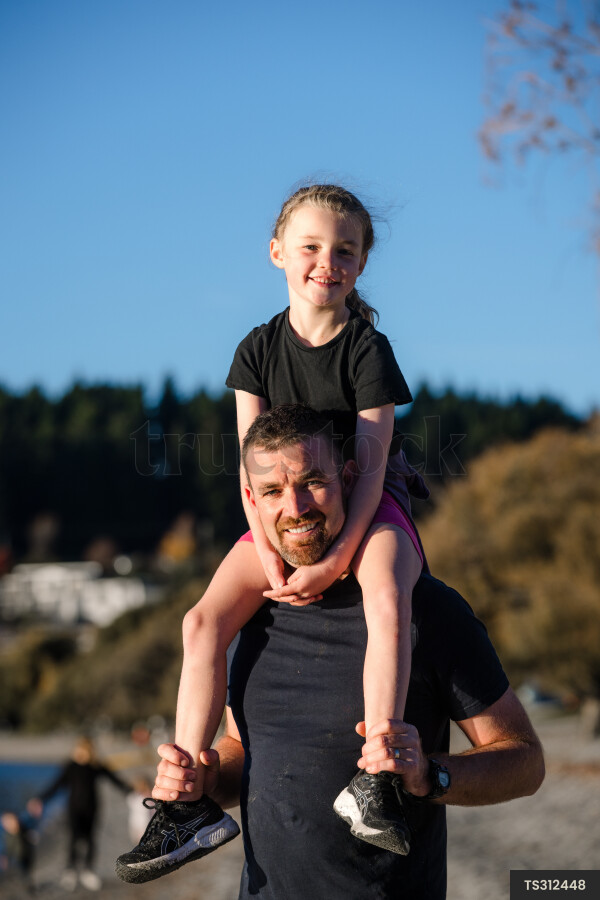 Father carrying daughter on shoulders