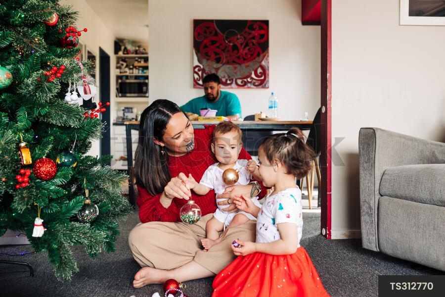 Mother and Kids Decorate Christmas Tree