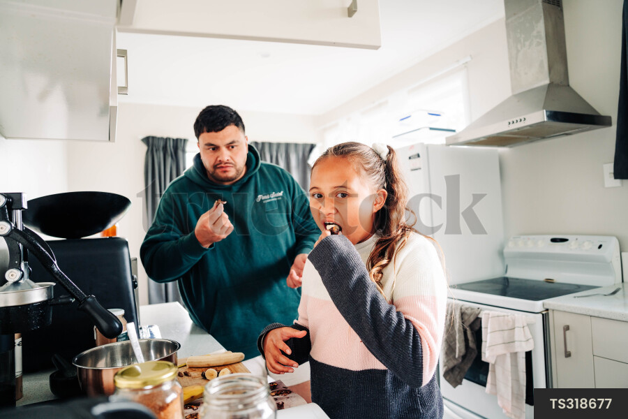 Girl and her father cooking in kitchen