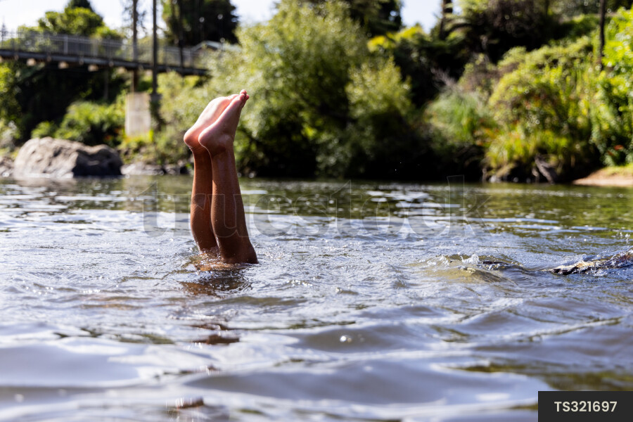 Boy doing handstand in river