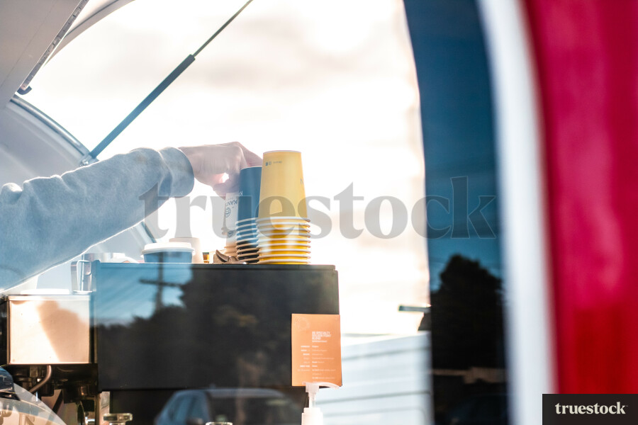 Adult making coffee order for a customer in a coffee truck roadside cafe