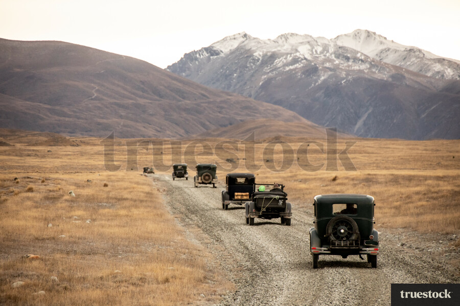 Vintage cars driving on a tekapo gravel road