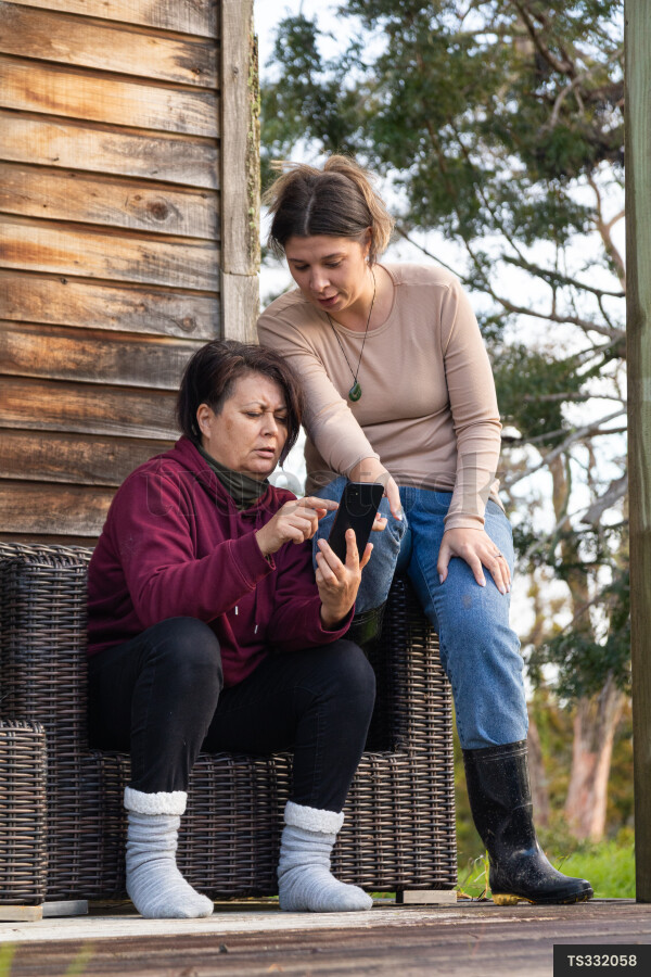 Family Using Phone on Deck